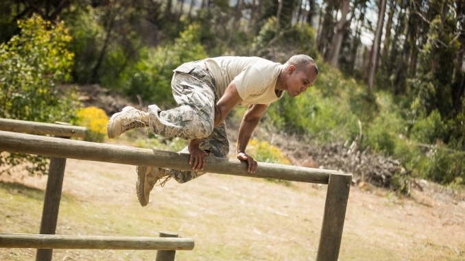 military man jumping hurdles