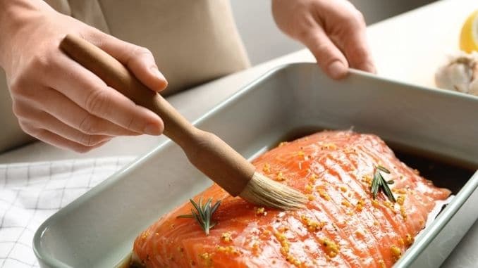Woman-marinating-raw-salmon