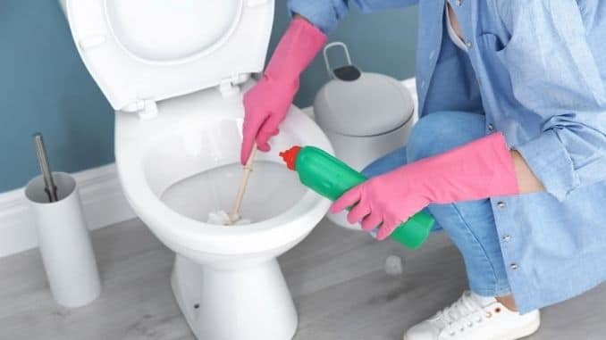 Woman-cleaning-toilet-bowl