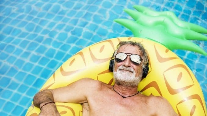 Closeup-of-caucasian-senior-man-in-the-pool-with-headphones.