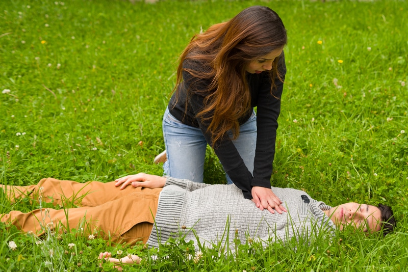 cardiopulmonary resuscitation, in a grass background