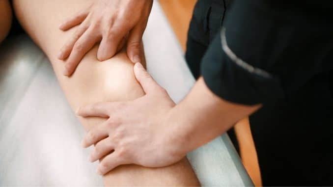 Physiotherapist checking patients knee