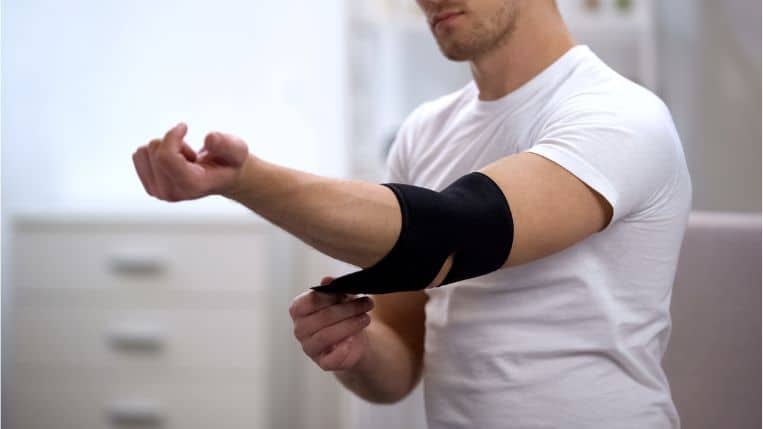 male-applying-elbow-padded-orthosis