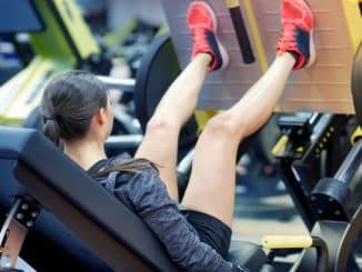 woman-flexing-muscles-leg-press