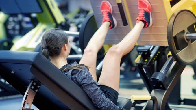 woman-flexing-muscles-leg-press